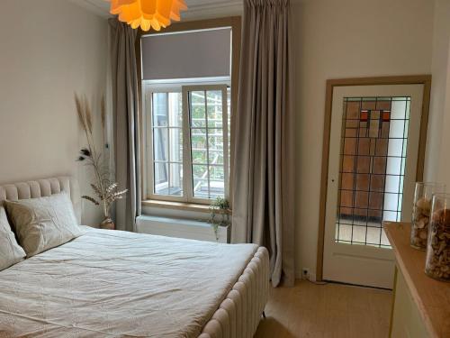 a bedroom with a white bed and a window at 'Lima' Luxe appartement in Vlissingen in Vlissingen