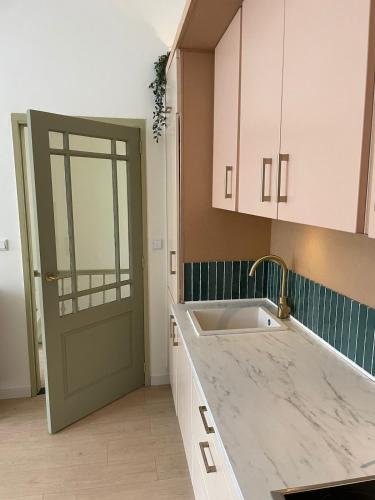 a kitchen with a sink and a green door at 'Lima' Luxe appartement in Vlissingen in Vlissingen