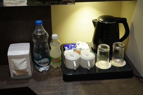a counter top with a coffee maker and bottles of water at Hotel P1 The Comfort Zone in Jalandhar