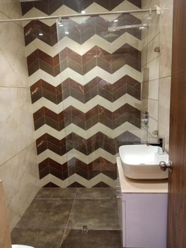 a bathroom with a sink and a tiled wall at Hotel P1 The Comfort Zone in Jalandhar