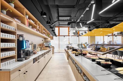 a large kitchen with a long counter with food at H2 Hotel Erfurt in Erfurt