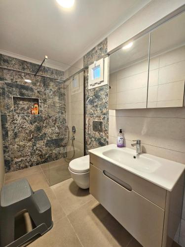 a bathroom with a sink and a toilet at Luxury 5BR Villa w Pool & Beach Access Ayvalık in Ayvalık