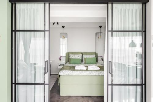 a bedroom with a bed with green pillows at Horizon Suite at Sea in Vlissingen