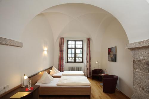 a hotel room with two beds and a window at Kloster Obermarchtal in Obermarchtal