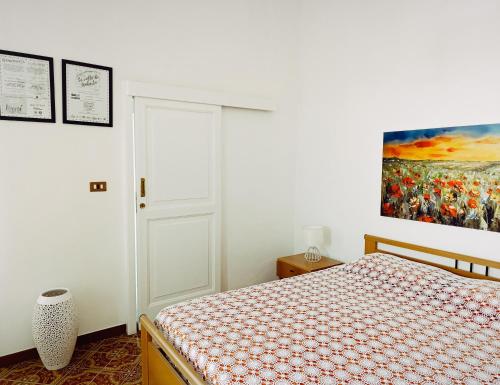 a bedroom with a bed and a painting on the wall at Le volte di Umberto Scirocco in Sogliano Cavour