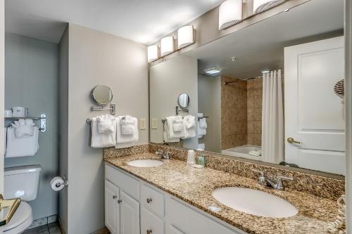 a bathroom with two sinks and a large mirror at Dunes Village in Myrtle Beach