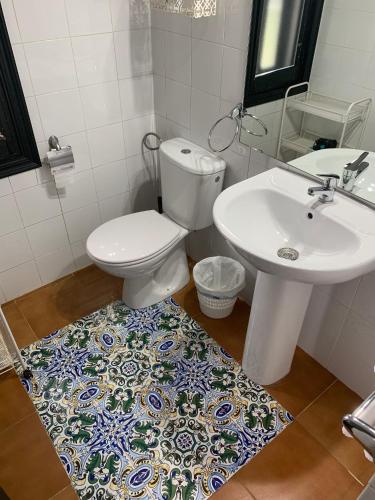 a bathroom with a toilet and a sink at Cortijo Majada de las Vacas in Santa Olalla del Cala