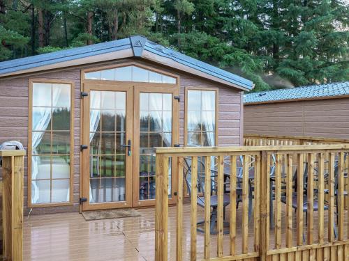 a gazebo with a glass door on a deck at The Orchard - Uk7111 in Alloa