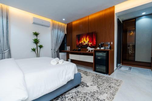 a bedroom with a white bed and a fireplace at Aurum on Missouri in Abuja