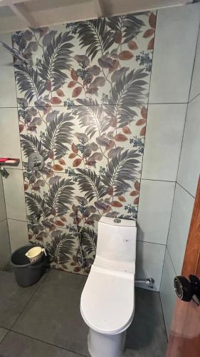 a bathroom with a white toilet in a room at Havmi Wellness Resort in Kumarakom