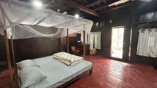 a bedroom with a bed with a canopy at Havmi Wellness Resort in Kumarakom