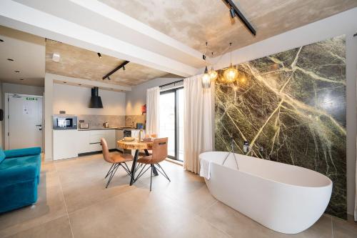 a bathroom with a tub and a table and a kitchen at Del Mar Court in Marsalforn