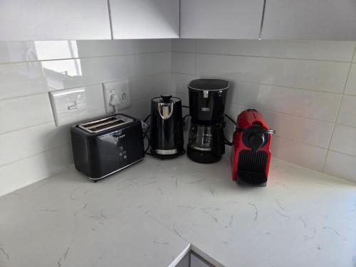 a kitchen counter with two coffee makers and a toaster at Casa Voliere in Stellenbosch
