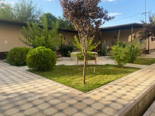 a garden with a small tree and a bench at Tashkent apart hotel in Tashkent
