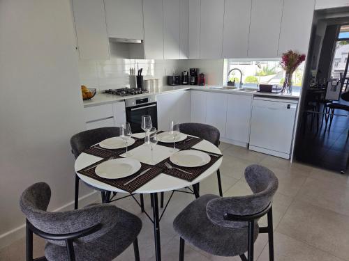 a kitchen with a white table and chairs and a table and chairsktop at Casa Voliere in Stellenbosch