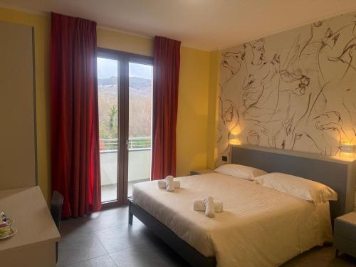 a bedroom with a bed and a large window at Hotel Piccolo Paradiso - Latronico "Terme" in Latronico