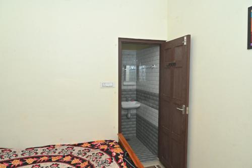a bathroom with a toilet and a sink next to a door at Nisarga Greens in Chittūr