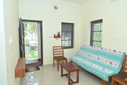 a living room with a bench and a chair at Nisarga Greens in Chittūr