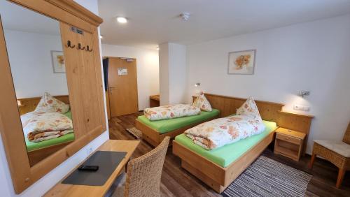 a room with two beds and a mirror at Mühldorfer Hof in Altötting
