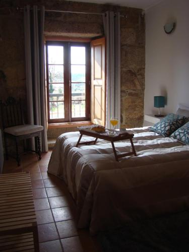 a bedroom with a bed with a table on it at Casa de Campo Patio do Avô - Varanda do Pátio in Routar