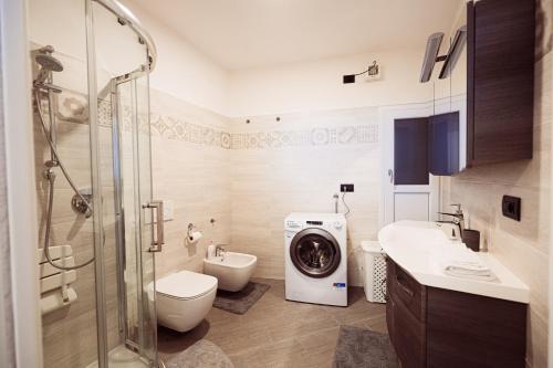 a bathroom with a toilet sink and a washing machine at Residenza Caterina in Maslianico