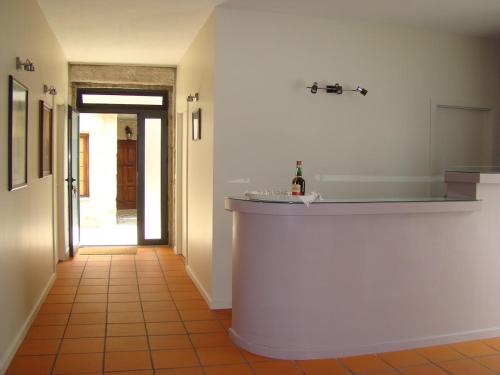 a kitchen with a white counter and a hallway at Casa de Campo Patio do Avô - Varanda do Pátio in Routar