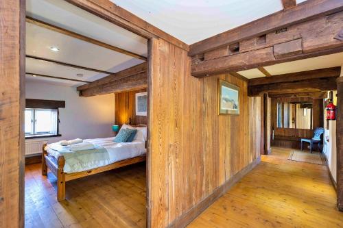 a bedroom with a bed in a room with wooden walls at Finest Retreats - Fletland Mill in Stamford