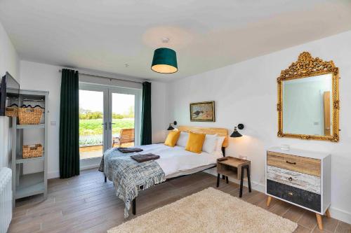 a bedroom with a bed with a mirror and a window at Finest Retreats - The Holt in Stamford
