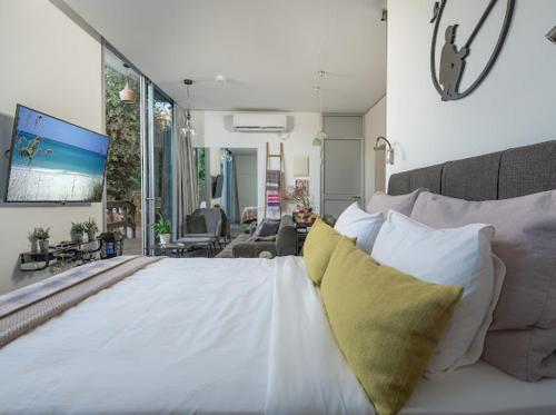 a bedroom with a white bed with a yellow pillow at Felina place by shuli in Ganne Yoẖanan