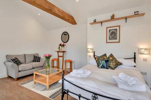 a bedroom with a bed and a couch and a table at Finest Retreats - The Den in Stamford