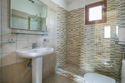 a bathroom with a sink and a toilet at Villa Sandy Cove by Villa Plus in Spartià