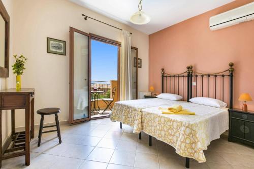 a bedroom with a large bed and a balcony at Villa Sandy Cove by Villa Plus in Spartià