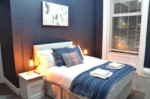 a bedroom with a bed with two towels on it at Manchester Ashton Suites in Ashton under Lyne