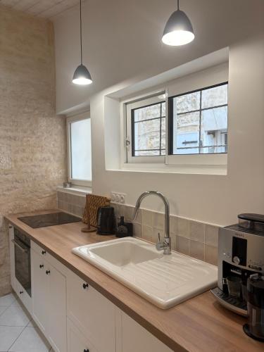a kitchen with a sink and two windows at BoomCoeur in Niort
