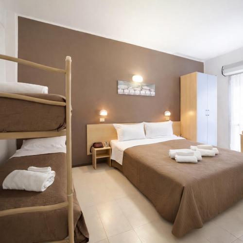 sypialnia z łóżkiem i dwoma łóżkami piętrowymi w obiekcie Hotel Adria Mare w Rimini