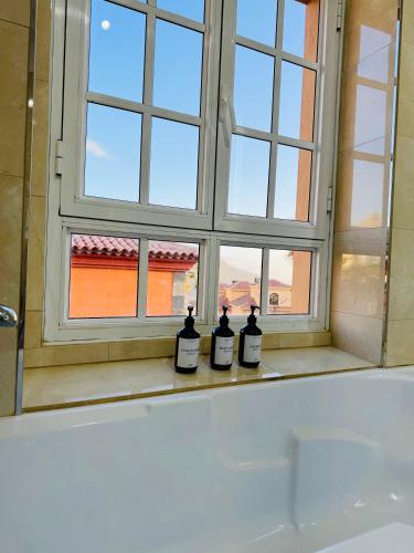 three bottles of wine sitting in front of a window at Villa Chayofa in Chayofa