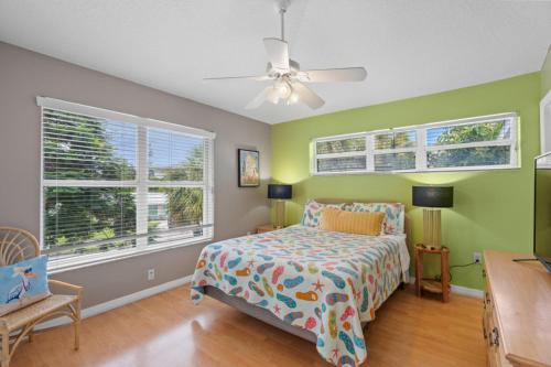 a bedroom with green walls and a bed and a ceiling fan at Siesta-Retreats - Key West Unit in Siesta Key