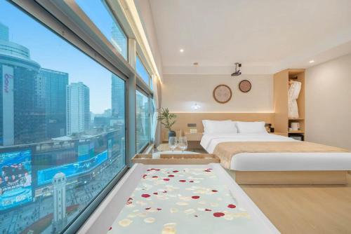 a bedroom with a bed and a large window at 妮可酒店解放碑店 in Chongqing