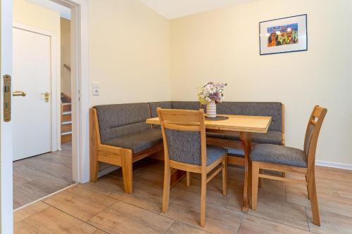 a dining room with a wooden table and chairs at Haus 1 Matrose in Kellenhusen