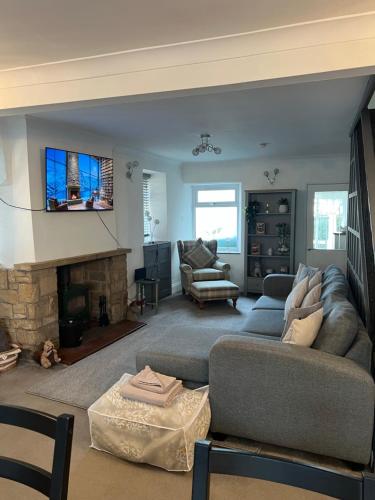 a living room with a couch and a fireplace at Epworth Cottage in Crich