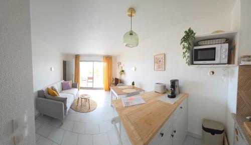 een keuken en woonkamer met een bank en een tafel bij Sous le Soleil in Fréjus
