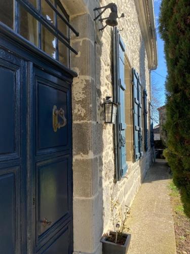 a building with a blue door and a plant next to it at Coeur de Calignac in Calignac
