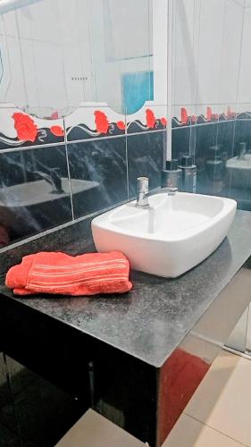 a bathroom sink with a red towel on a counter at Sonho de verão in Guarulhos