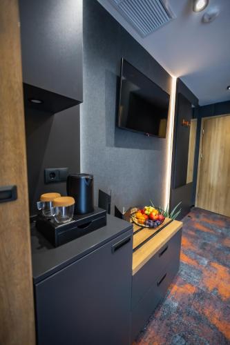 a kitchen with a stove and a bowl of fruit on a counter at 4 Évszak Erdeihotel**** - Mátrafüred in Mátrafüred