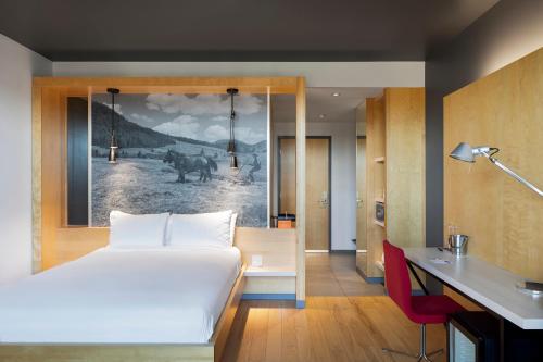 a bedroom with a bed and a painting on the wall at Hôtel & Spa Le Germain Charlevoix in Baie-Saint-Paul