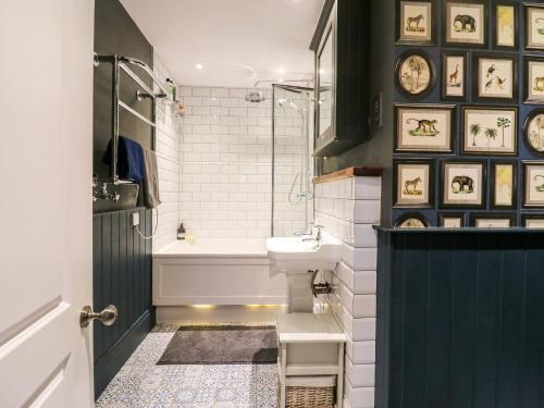 a bathroom with a sink and a tub and a toilet at River Haven - River Thames frontage house in Thames Ditton