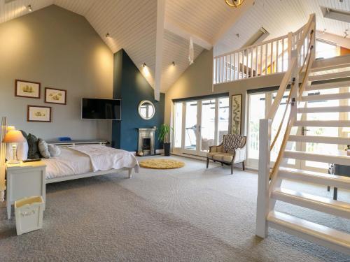a bedroom with a bed and a staircase in it at River Haven - River Thames frontage house in Thames Ditton