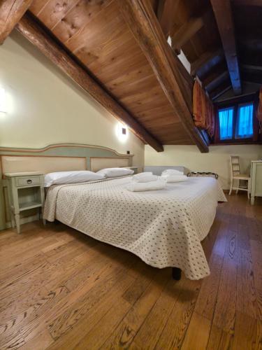 a bedroom with a large bed in a room with wooden floors at Hotel Chalet d'Oulx in Oulx