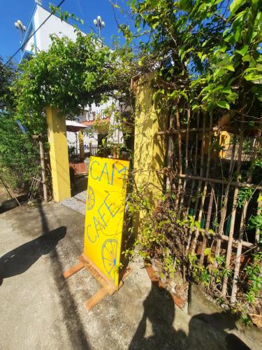 a yellow sign with graffiti on it next to a fence at Orange Beach House in Phú Quí (2)