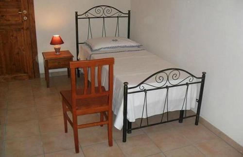 a bedroom with a bed and a chair and a table at Masseria Sucéa in Martano